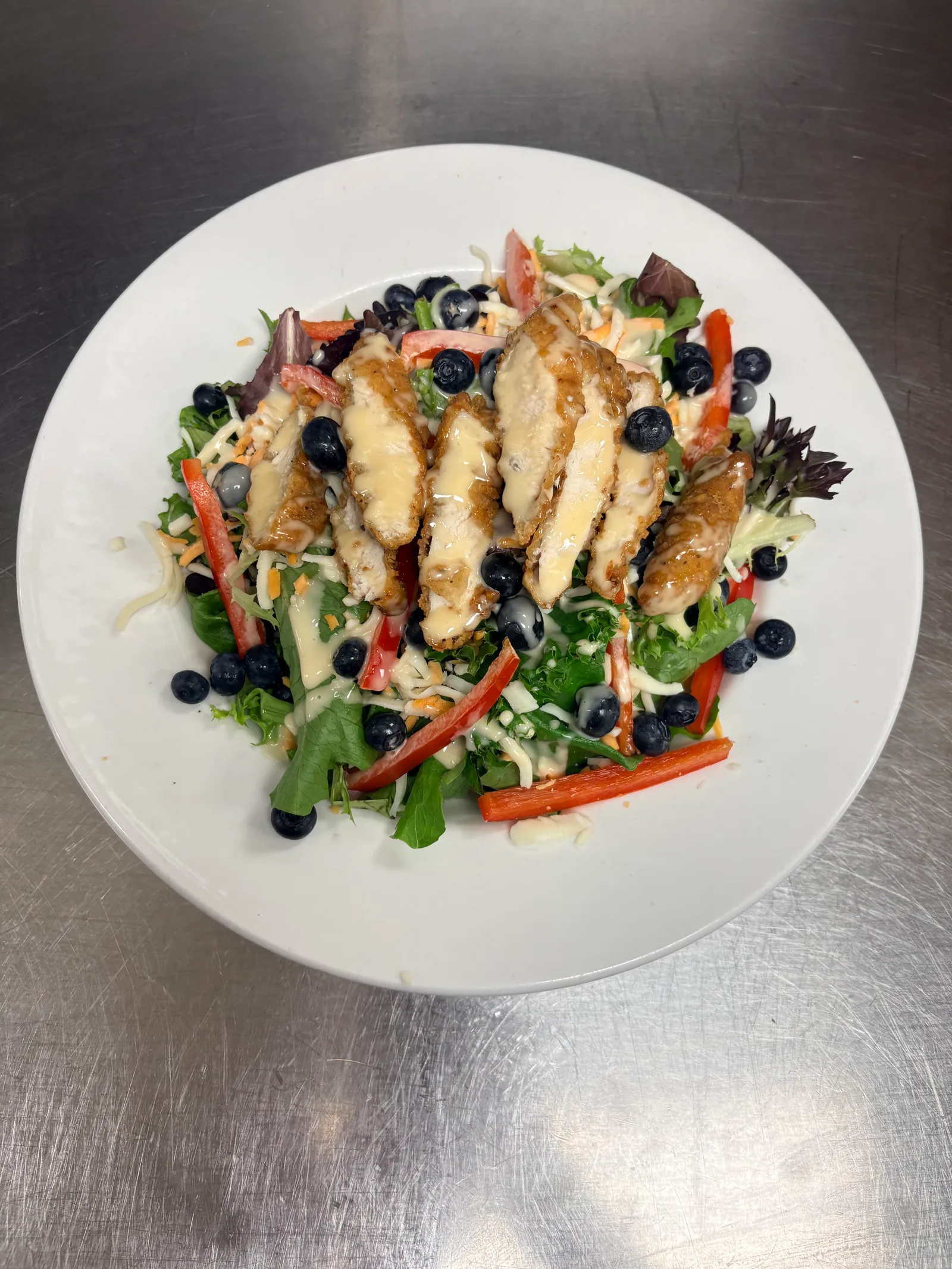Chicken blueberry salad: mixed greens topped with crispy chicken, shredded cheese, fresh blueberries and homemade maple dressing at Blue Canoe at the Lincoln Big Stop